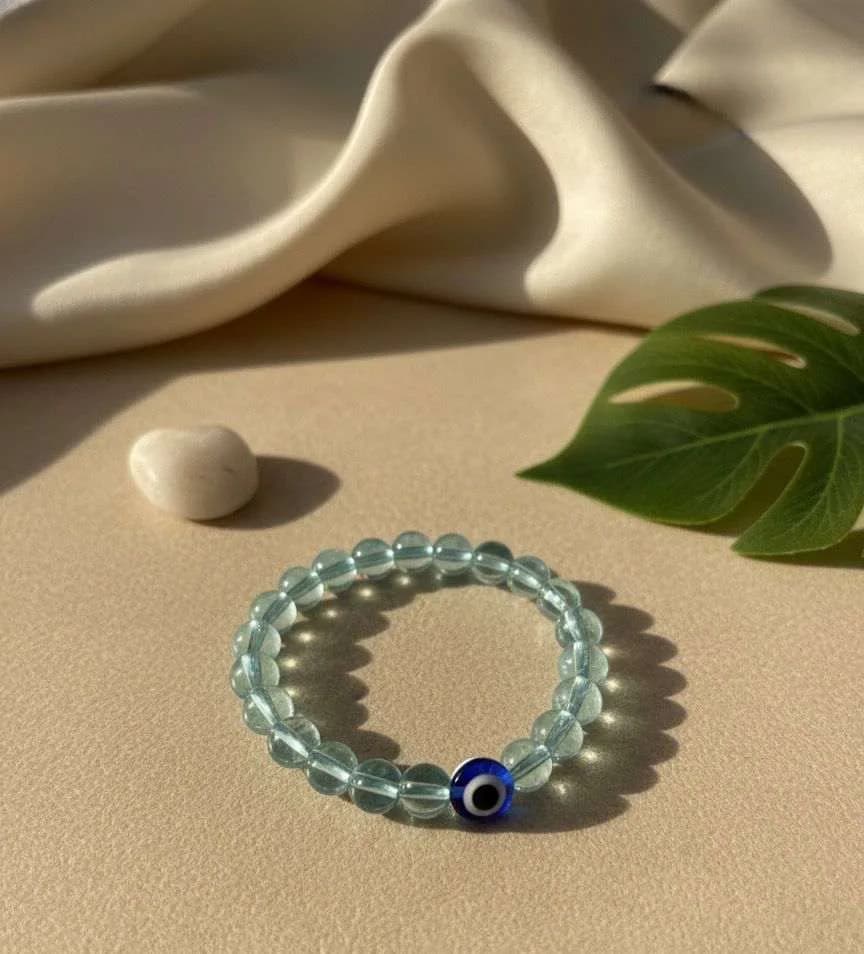 Light blue Aquamarine bead bracelet with a central Evil Eye amulet.